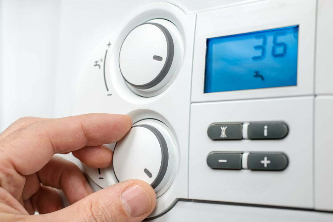 adjusting_thermostat Plumbing and Heating Engineers